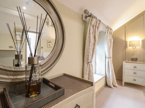La salle de bains est pourvue d'un grand miroir et d'un vase sur une table. dans l'établissement 14 Crown Lane, à Conwy