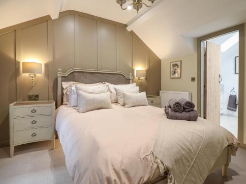 - une chambre avec un grand lit blanc et des serviettes dans l'établissement 14 Crown Lane, à Conwy
