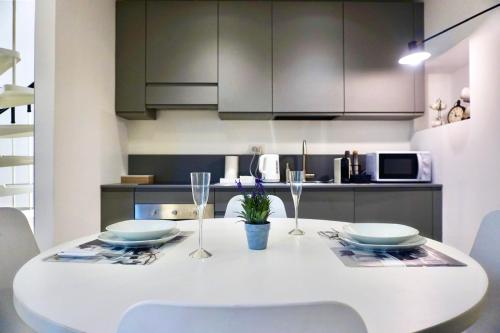 a white dining room table with chairs and a kitchen at LOFT 10 in Varese