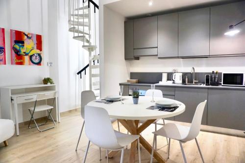 a kitchen and dining room with a white table and chairs at LOFT 10 in Varese