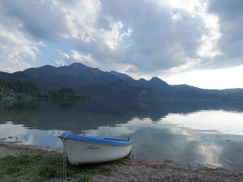 a boat sitting on the shore of a lake at Boutique Hotel Angerer in Murnau am Staffelsee