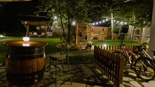 a patio with a table and chairs and a barrel at B&B Plitvice Holiday Lodge in Plitvička Jezera