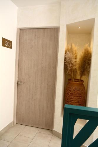 a wooden door in a room with a vase at Zentrico Boutique in Pereira