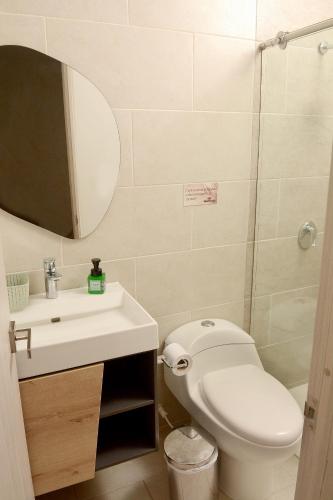 a bathroom with a toilet and a sink and a mirror at Zentrico Boutique in Pereira