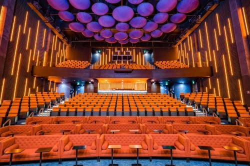 an empty auditorium with orange chairs and purple balloons at Nickelodeon Hotels & Resorts Riviera Maya All Inclusive in Puerto Morelos