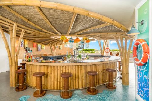 un bar en un complejo con taburetes de madera en Nickelodeon Hotels & Resorts Riviera Maya - Gourmet All Inclusive by Karisma en Puerto Morelos