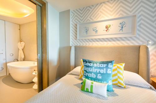 Un dormitorio pequeño con una cama y un baño. en Nickelodeon Hotels & Resorts Riviera Maya - Gourmet All Inclusive by Karisma, en Puerto Morelos
