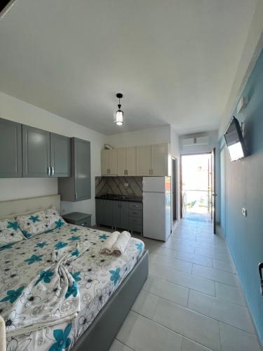 a bedroom with a large bed and a kitchen at Kamberi Hotel & Apartments 2 in Velipojë