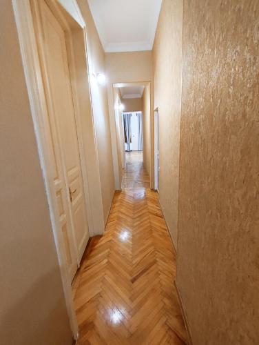 a hallway of an apartment with wooden floors and walls at Happy Stay Hotel in Kutaisi