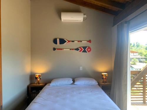 una camera da letto con un letto con una bandiera sul muro di Casa de Praia no Rosa - Vista Espetacular a Praia do Rosa