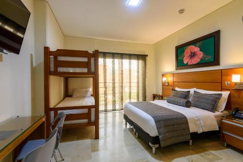 a bedroom with a bunk bed and a desk at Hotel Dorado La 70 in Medellín