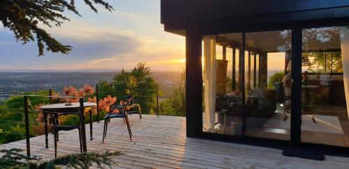 Casa con terraza con mesa y sillas en lodge-bélvédere sur les hauteurs de vichy, en Vichy