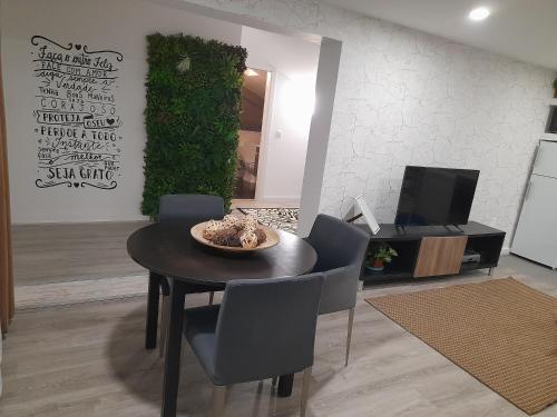 a dining room with a table and chairs and a tv at Open Home - Lisbon/Almada in Almada