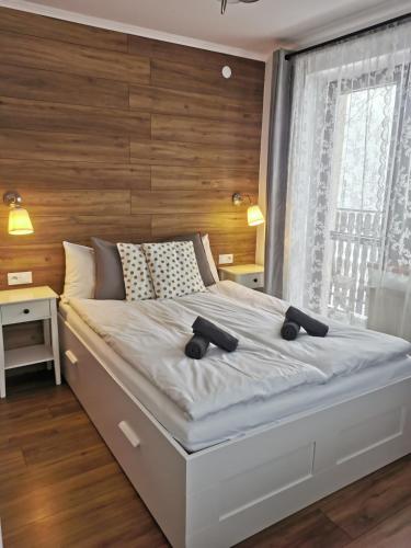 a bedroom with a large bed with a wooden wall at Rodzinna Ostoja in Zakopane