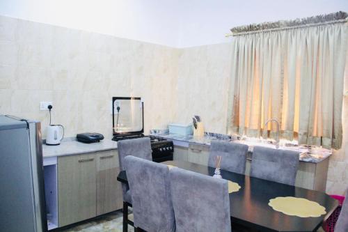 a kitchen with a table and chairs and a counter top at Jama Residence in Abuja