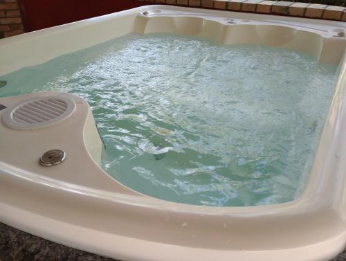 a bath tub filled with blue water with a drain at Sitio Libardo em Meio a Natureza - Nova Trento in Nova Trento