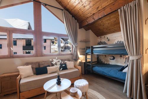 a living room with a bunk bed and a couch at Le Chalerick - triplex rénové 6 à 8 personnes - hyper centre Valmeinier 1800 - ski aux pieds in Valmeinier