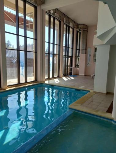 a large swimming pool with blue water in a building at Magnifique Appartement Valberg in Péone