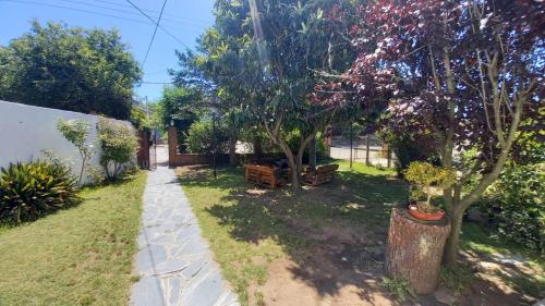 un jardin avec deux arbres et un trottoir dans l'établissement Casa del Mar, à Villa Gesell