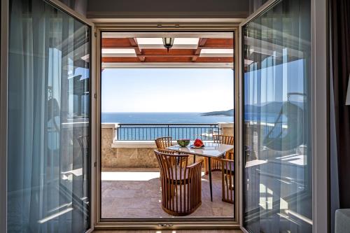 uma varanda com uma mesa e vista para o oceano em Lustica Apartments Marina em Tivat