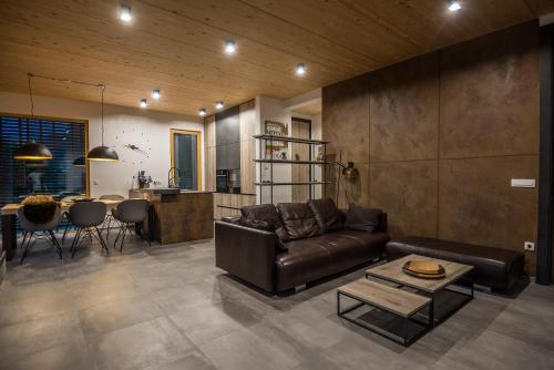 - un salon avec un canapé en cuir et une table dans l'établissement Residence Novak Bohinj, à Bohinj