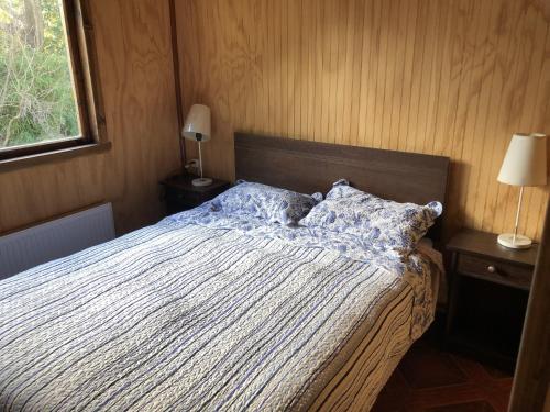 a bedroom with a bed and two lamps and a window at El Refugio de la Cuenca in Puerto Clocker