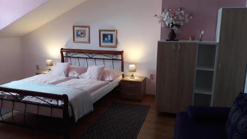 1 dormitorio con 1 cama con sábanas y almohadas blancas en Privát JOZEF, en Vrbov