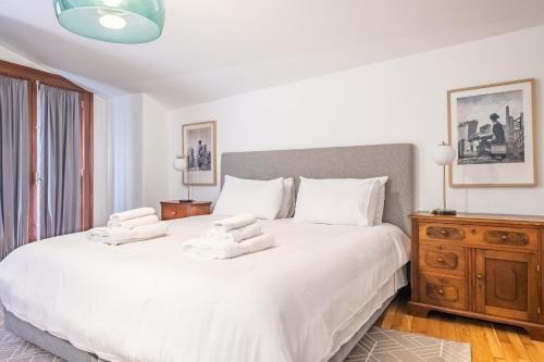 a bedroom with a large white bed with towels on it at Apartament 6 - By WeHost in Funchal