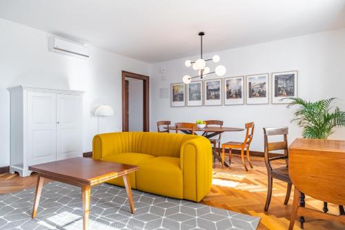 a living room with a yellow couch and a table at Apartament 6 - By WeHost in Funchal
