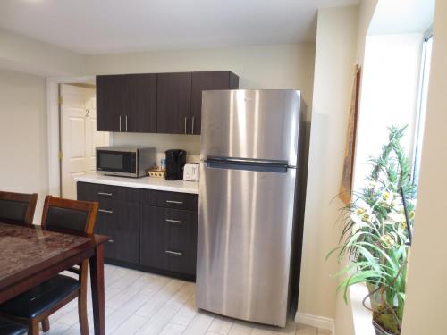 a stainless steel refrigerator in a kitchen with a table at Entire Cozy Basement! Private Entrance! - Fast Wifi! in Salt Lake City