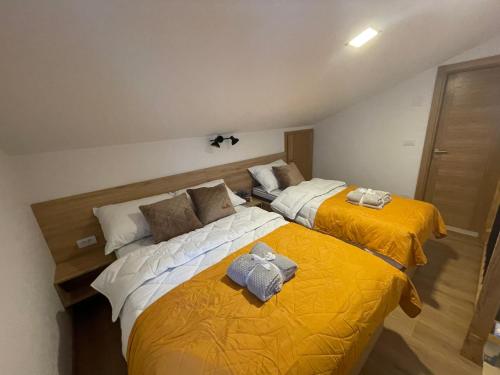 two beds in a room with yellow and white at Vila Jahor Superior Apartman 16 “Minja” in Jahorina