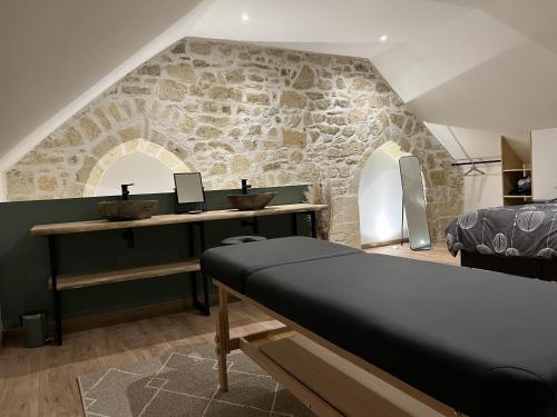 a bedroom with a bed and a stone wall at Appart Spa Privatif Laon in Laon