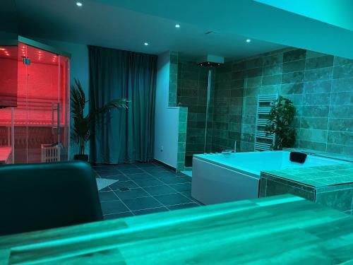 - une chambre avec une baignoire dans une chambre dotée de lumières rouges dans l'établissement Appart Spa Privatif Laon, à Laon