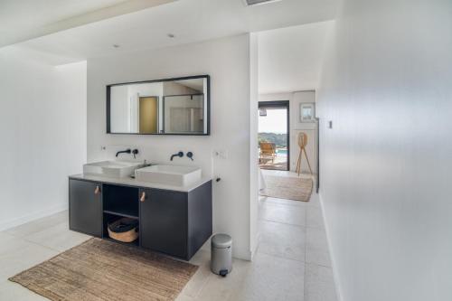 uma casa de banho branca com um lavatório e um espelho em Villa 250m 8 adultes 4 enf vue mer em La Croix-Valmer