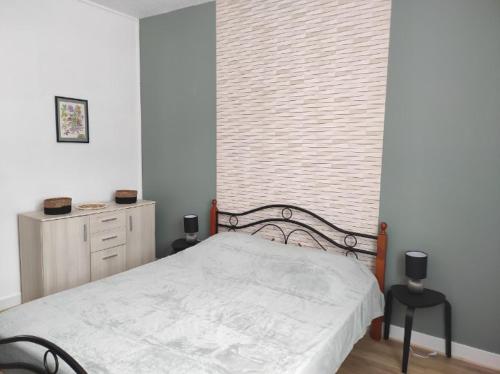 a bedroom with a white bed and a window at Iris, Gîte Saint Antoine, Orcival, entre Sancy et Volcans d'Auvergne in Orcival