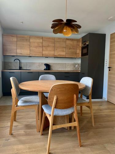 une cuisine avec une table et des chaises en bois dans l'établissement L'endroit idéal, confort et élégance, à Boulogne-sur-Mer