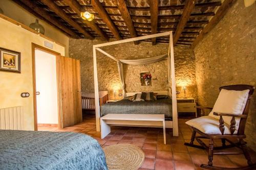 Bisbal del PenedèsにあるCatalunya Casas Captivating Villa in the Vineyard close to Sitgesのベッドルーム(天蓋付きベッド1台、椅子付)