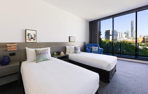 a hotel room with two beds and a large window at Alpha Mosaic Hotel Fortitude Valley Brisbane in Brisbane