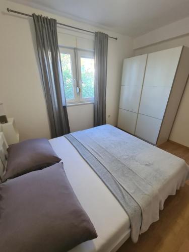 - une chambre avec un grand lit et une fenêtre dans l'établissement Apartment Melody, à Metković