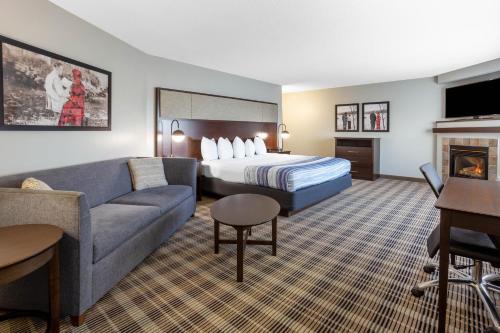 Habitación de hotel con cama y sofá en AmericInn by Wyndham Madison South en Madison