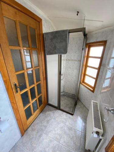 a bathroom with a shower and a wooden door at Kawi Hotel in Puerto Natales