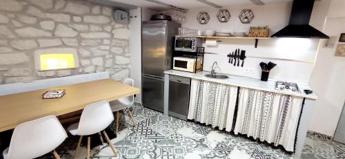 cocina con encimera, mesa y sillas en Bodega Ca'tio Celso, en San Esteban de la Sierra
