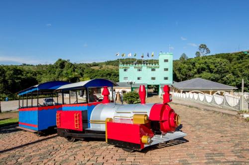 a small train on display on a brick road at Parque Hotel Pimonte 