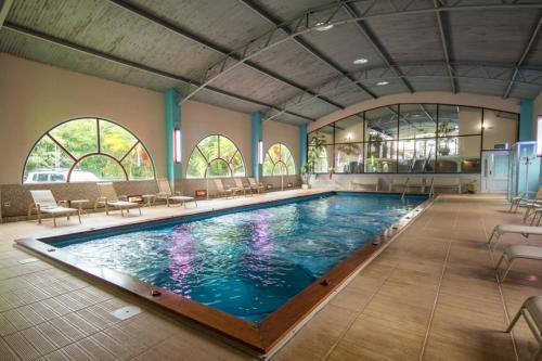 una gran piscina con sillas y mesas en un edificio en Parque Hotel Pimonte, 