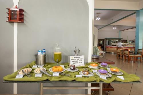 São Francisco de PaulaにあるParque Hotel Pimonteのテーブル(上に食べ物と飲み物付)