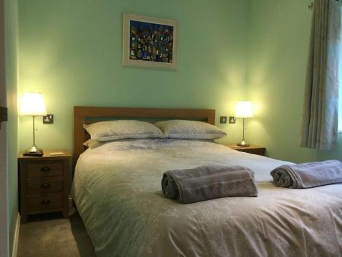 a bedroom with a large bed with two pillows on it at Beautifully appointed & cosy self contained annexe 