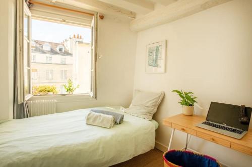 - une chambre avec un lit et un ordinateur portable sur un bureau dans l'établissement Notre-Dame -Latin Quarter VIP Rooftop terrace view, à Paris