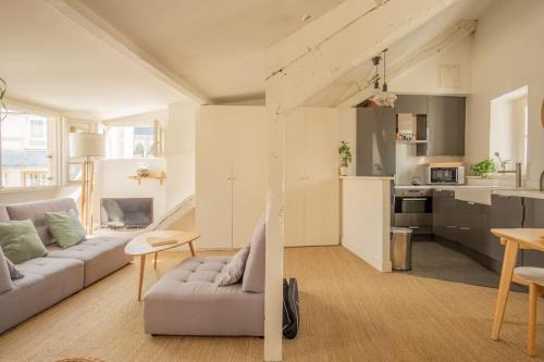 un salon avec un canapé et une cuisine dans l'établissement Notre-Dame -Latin Quarter VIP Rooftop terrace view, à Paris