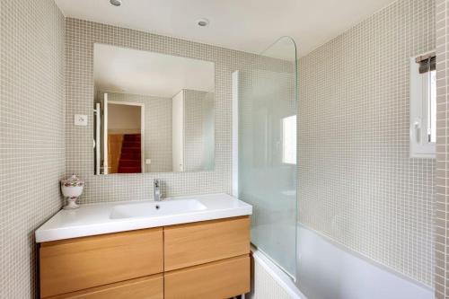 une salle de bain avec un lavabo et un miroir dans l'établissement Notre-Dame -Latin Quarter VIP Rooftop terrace view, à Paris