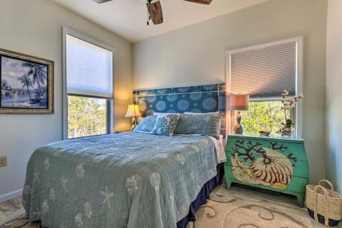 um quarto com uma cama azul e 2 janelas em East Bay Vacation Rental with Dock! em Navarre